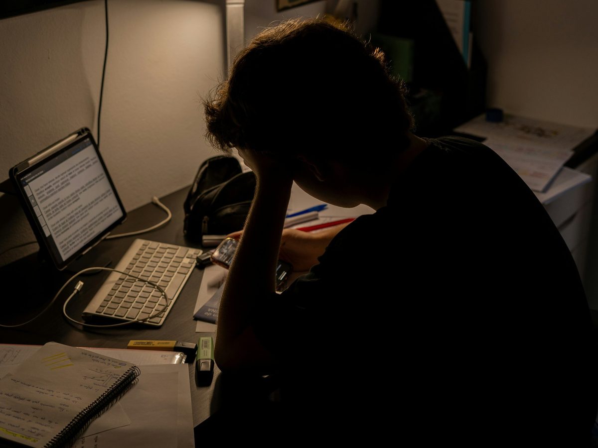 A business owner working through paperwork at a desk late at night